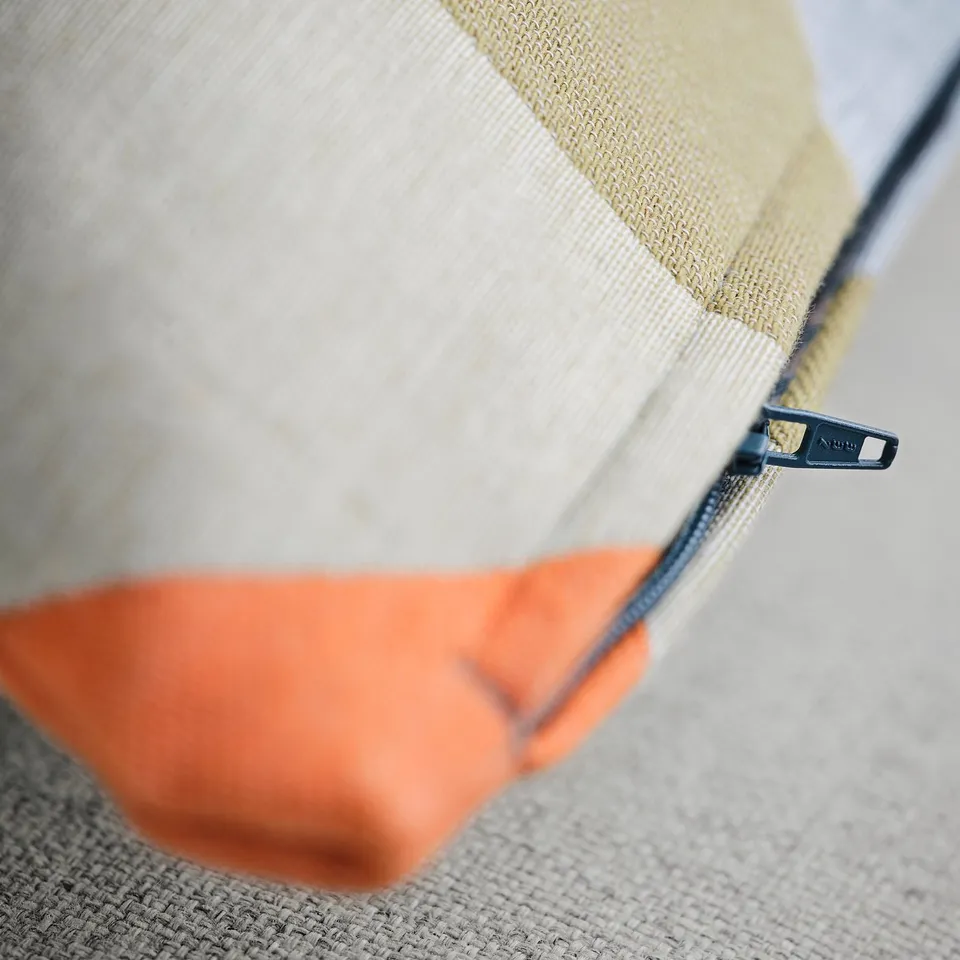 Close-up of zipped cushion cover with detailed, thick-woven texture.