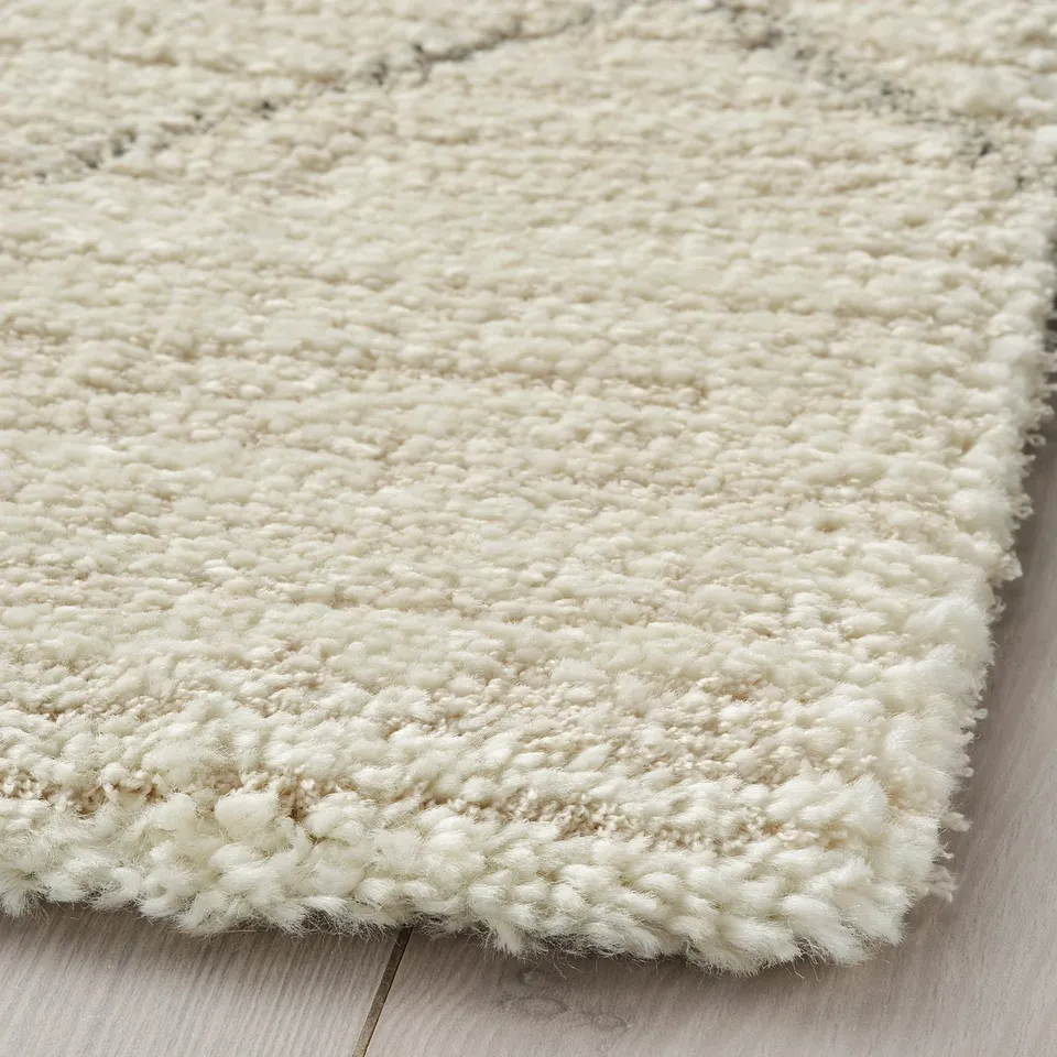 Close-up of TVERSTED rug corner, dense, soft texture, neutral colour, plush material.