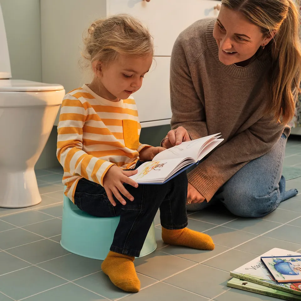 Child and person reading in bathroom.