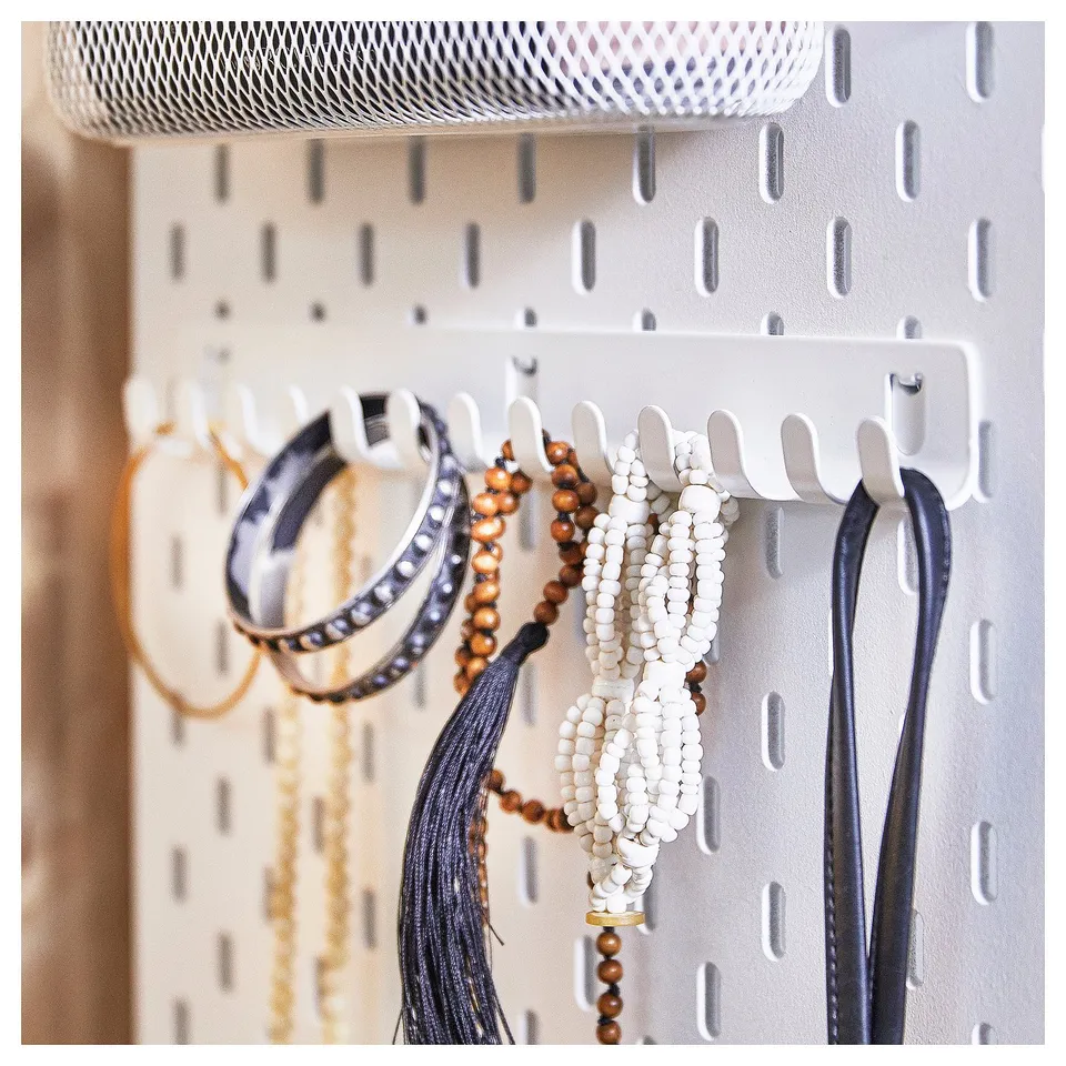 SKÅDIS white pegboard with jewellery hooks, holding necklaces and bracelets.