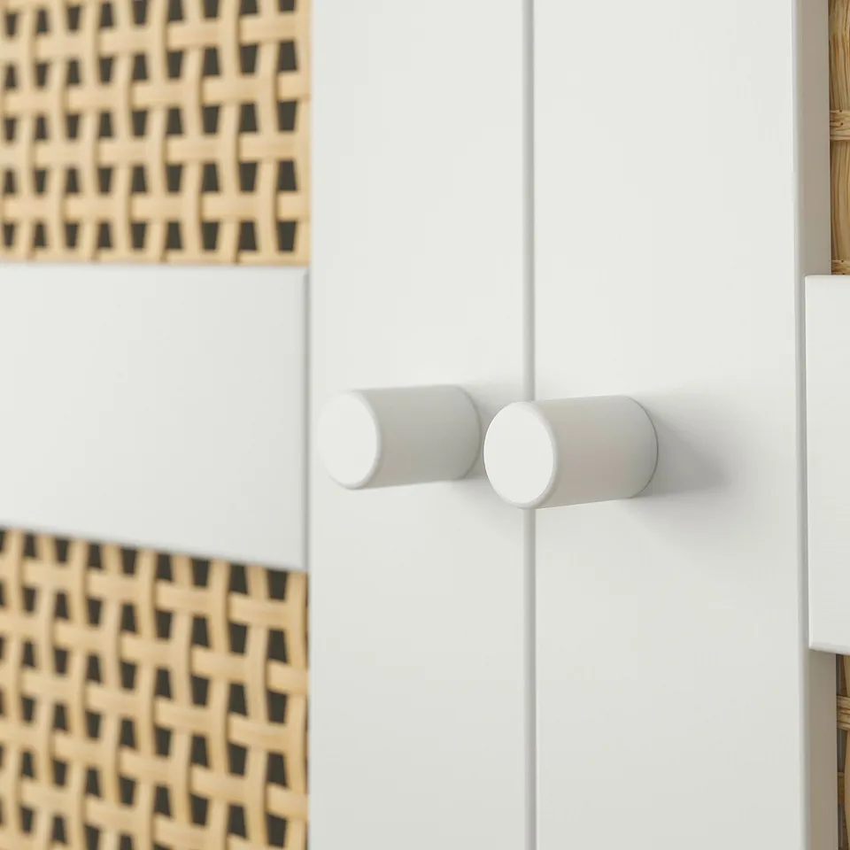 A close-up of a white BILLY bookcase handle made of cylindrical knobs.