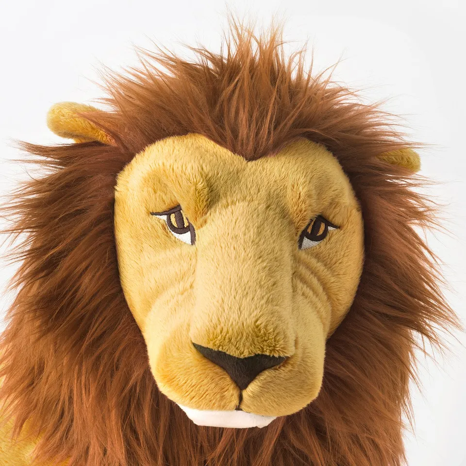 Soft lion toy with golden fur, dark mane, and black nose, perfect for hugging.