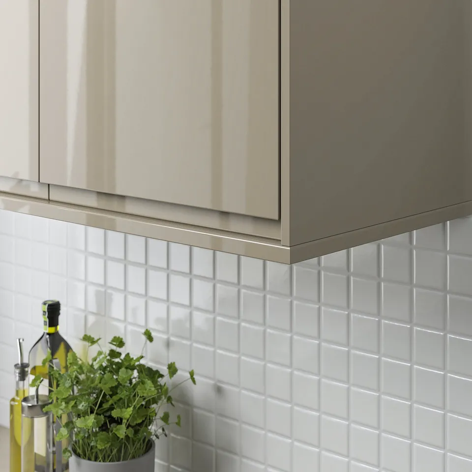 Modern kitchen with grey cabinets; white tiles and a plant on the counter.