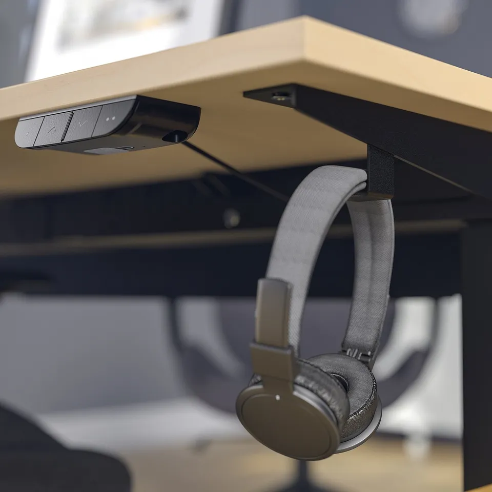 Desk with mounted control panel and hanging headphones.
