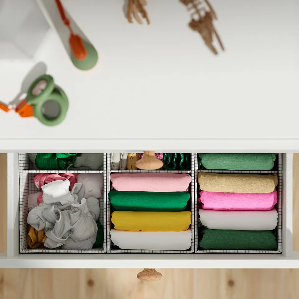 Organised drawer storage with folded clothes in compartments. Adjustable dividers create sections for different items.