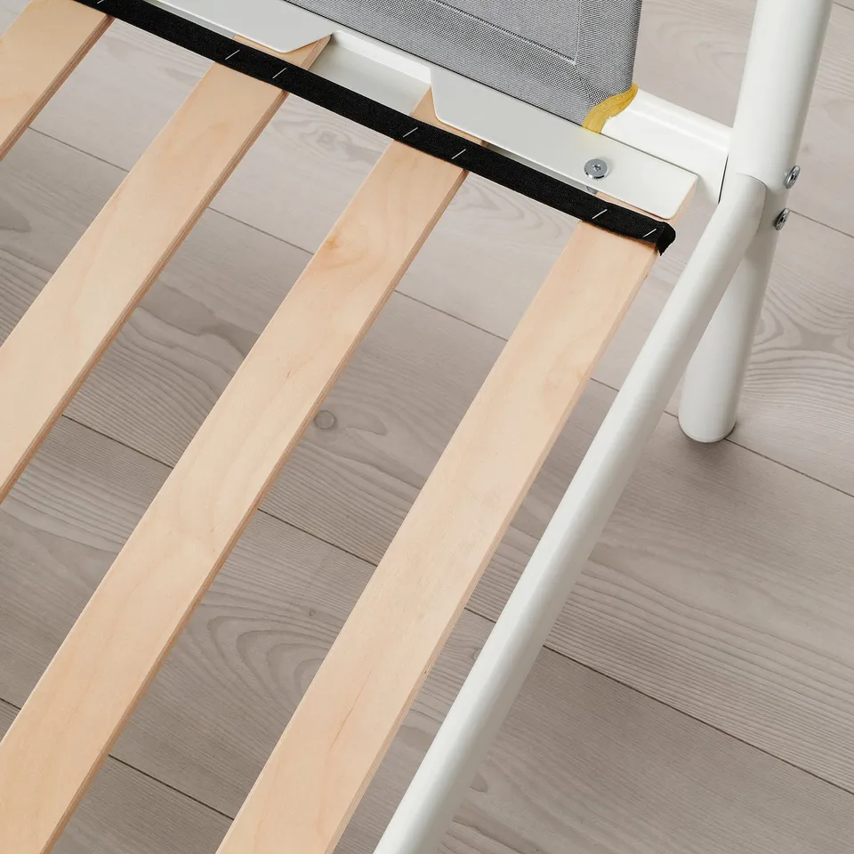 A close-up of a bunk beds ladder, showing the white metal frame and wooden steps.