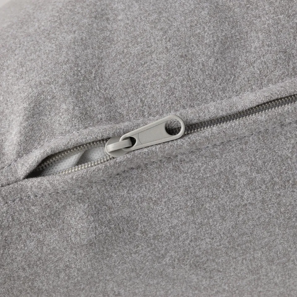 Close-up of quality zip on grey sofa, showing durable pull and smooth teeth.