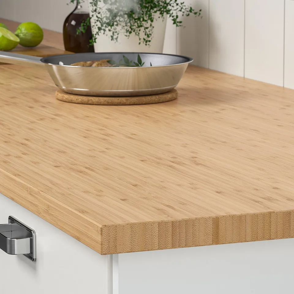 Wooden kitchen countertop with a frying pan, showcasing durability and stylish design. Ideal for food prep and cooking.