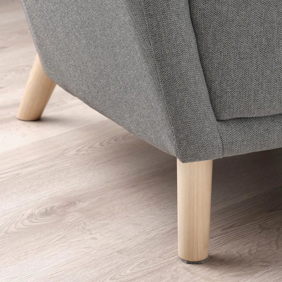 Close-up of modern, upholstered wing chair with sturdy wooden legs, showcasing quality and comfort.