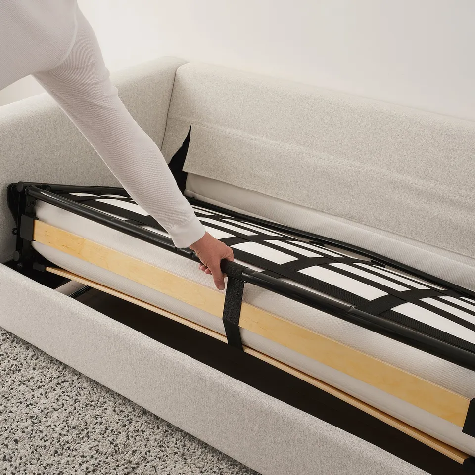 Person adjusting VIMLE sofa-beds metal frame. Easy setup and transformation.