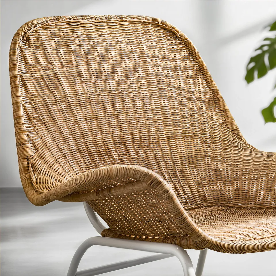 Wicker chair close-up, showing handwoven rattan seat, armrests, and backrest. Natural material, durable, and lightweight.