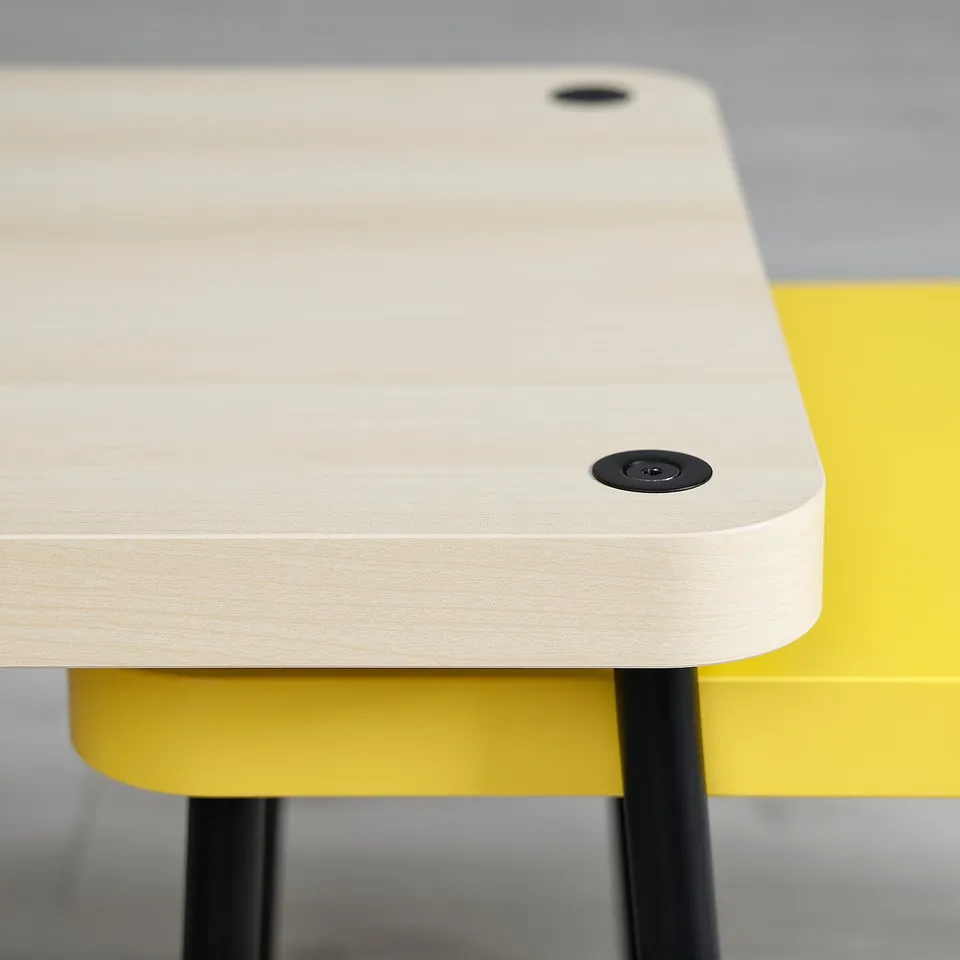 Two modern, light wooden nesting tables with black fixtures and bright yellow bases, shown from a side angle.