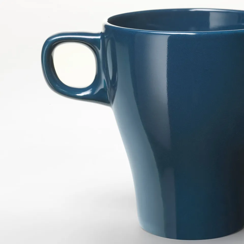 Close-up of deep blue, glossy mug with sturdy handle.