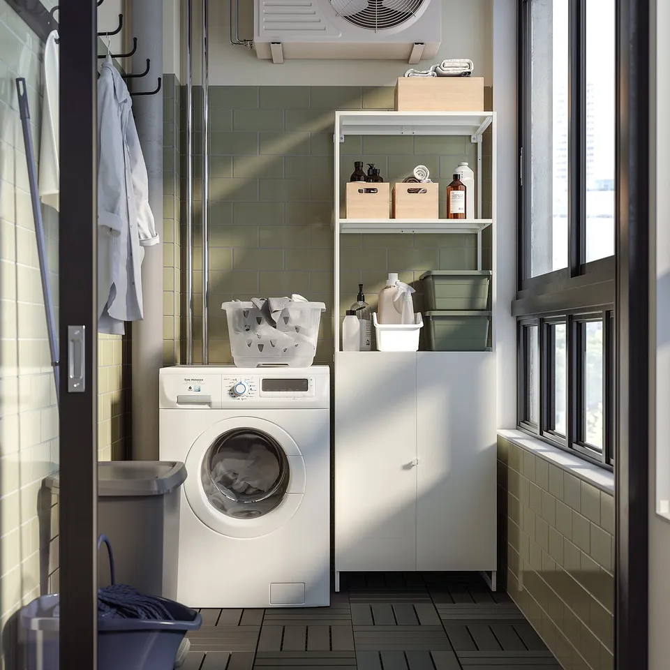 Small white laundry room with washing machine, shelves, and storage.
