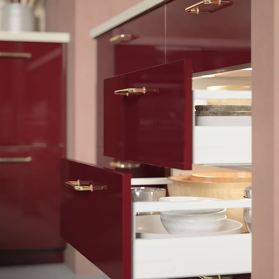 Modern kitchen drawer with MITTLED red cabinets, sleek handles, white bowls inside, ambient lighting.