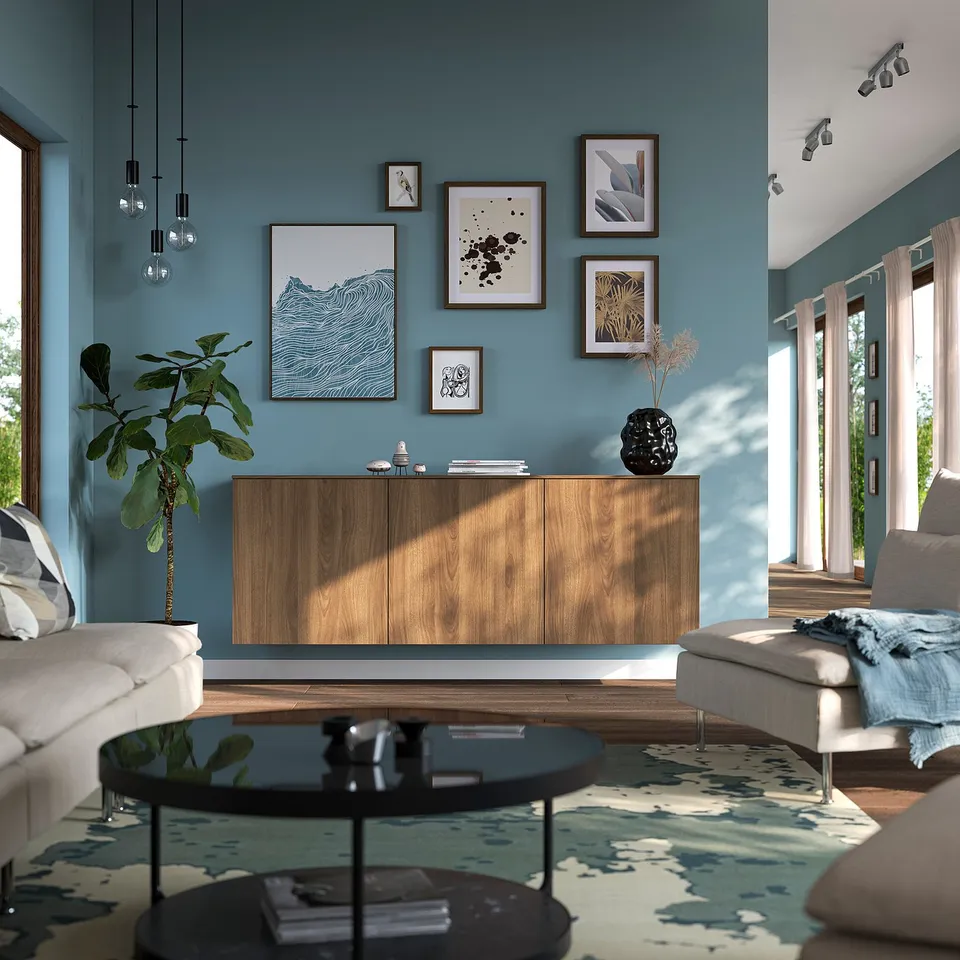Modern living room with BESTÅ sideboard, sofas, plants, art, rug. Blue walls, natural light.
