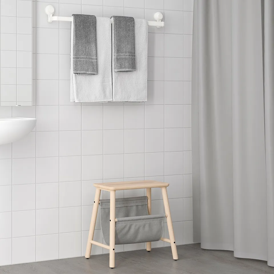 TISKEN wood & grey fabric stool, minimalist design. Folds flat, fits neatly in corner beside shower curtain.