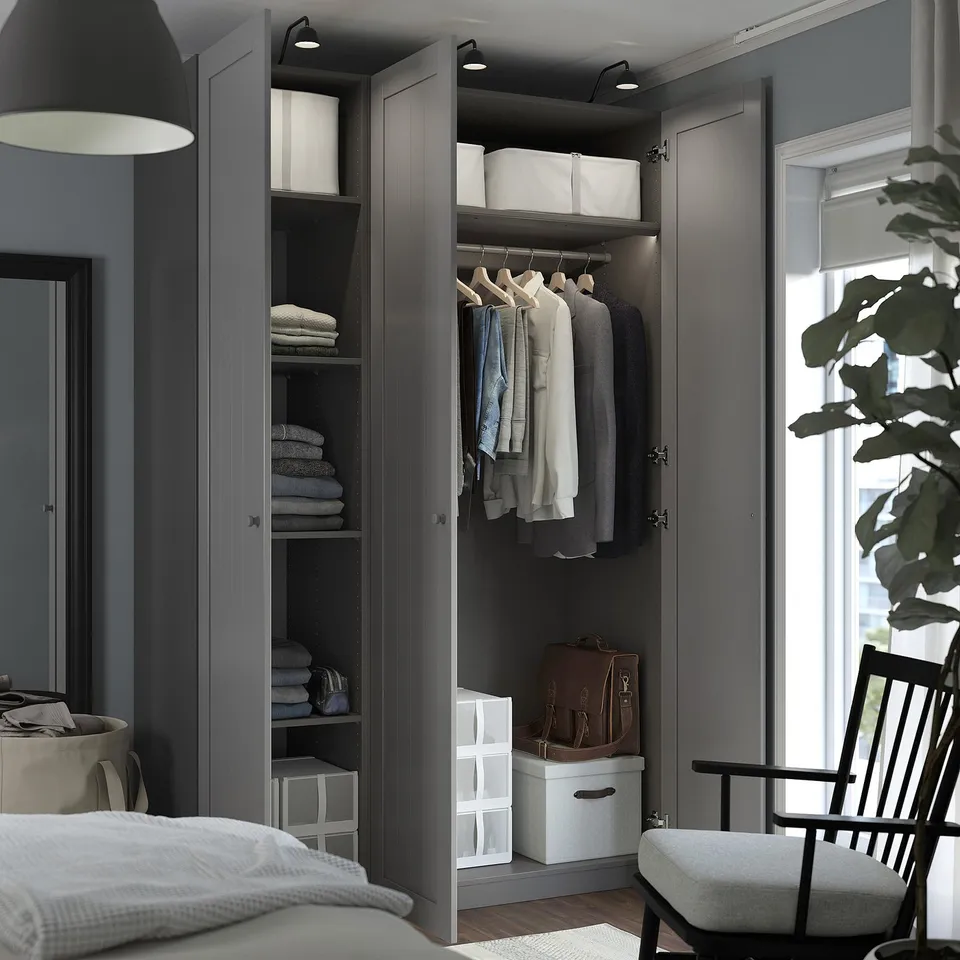 Modern bedroom with open wardrobe, clothes, towels, and accessories neatly organised inside. Soft-closing hinge and adjustable feet visible.
