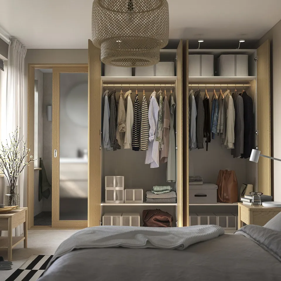 Modern bedroom with open wardrobe and neat clothes. Soft lighting.