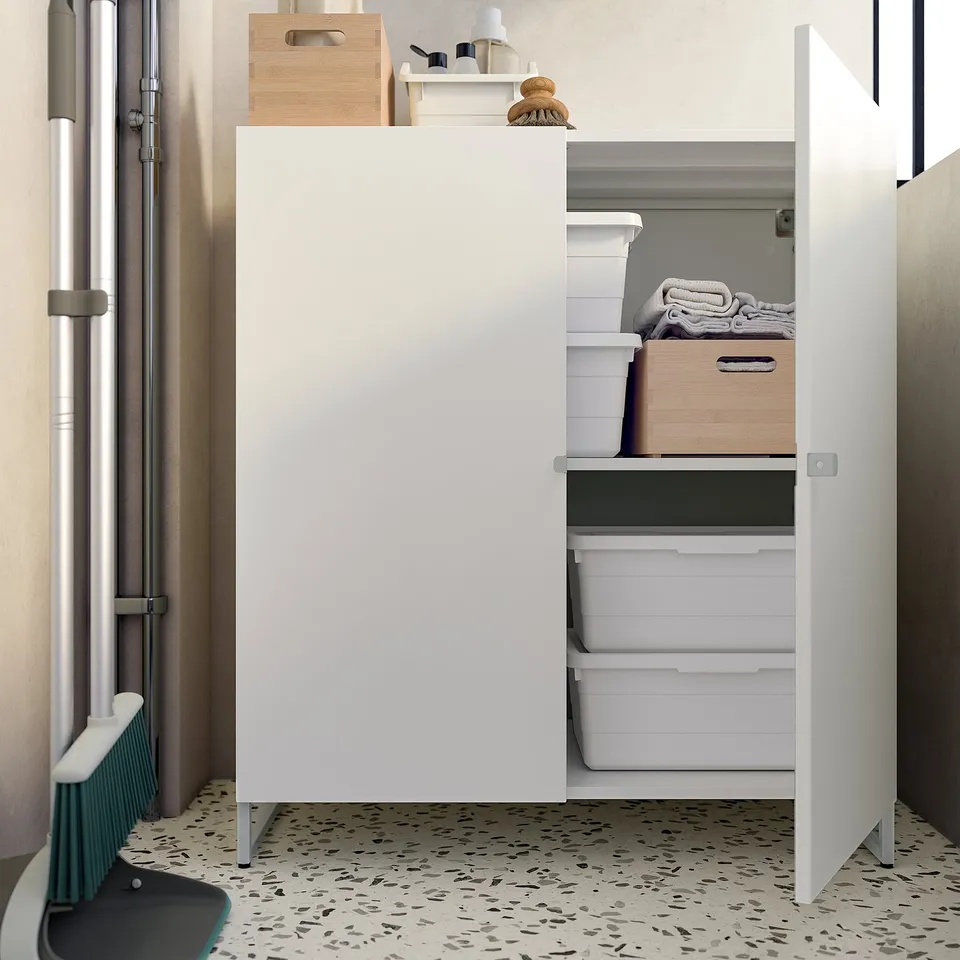 Moisture-resistant white JOSTEIN storage cabinet, with three drawers and wooden top, neatly organised for small spaces.