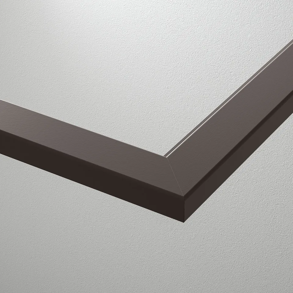 A close-up of a sleek, modern glass shelf, framed by a dark, polished edge, against a light grey wall.