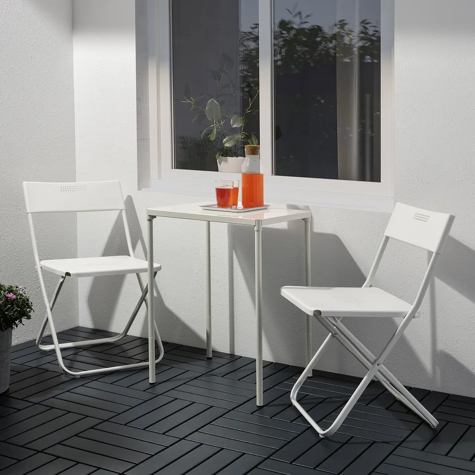 Small outdoor setting with white FEJAN table and chairs, perfectly sized for balconies.