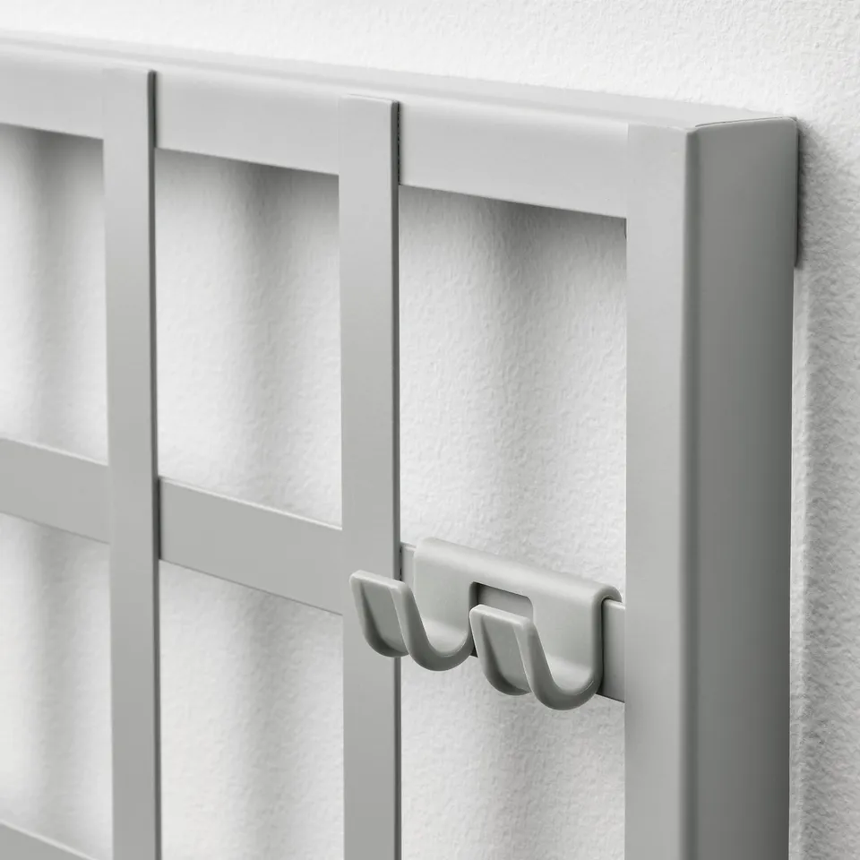 Modern wall-mounted organiser with hooks and compartments. Elegant white design for efficient storage.