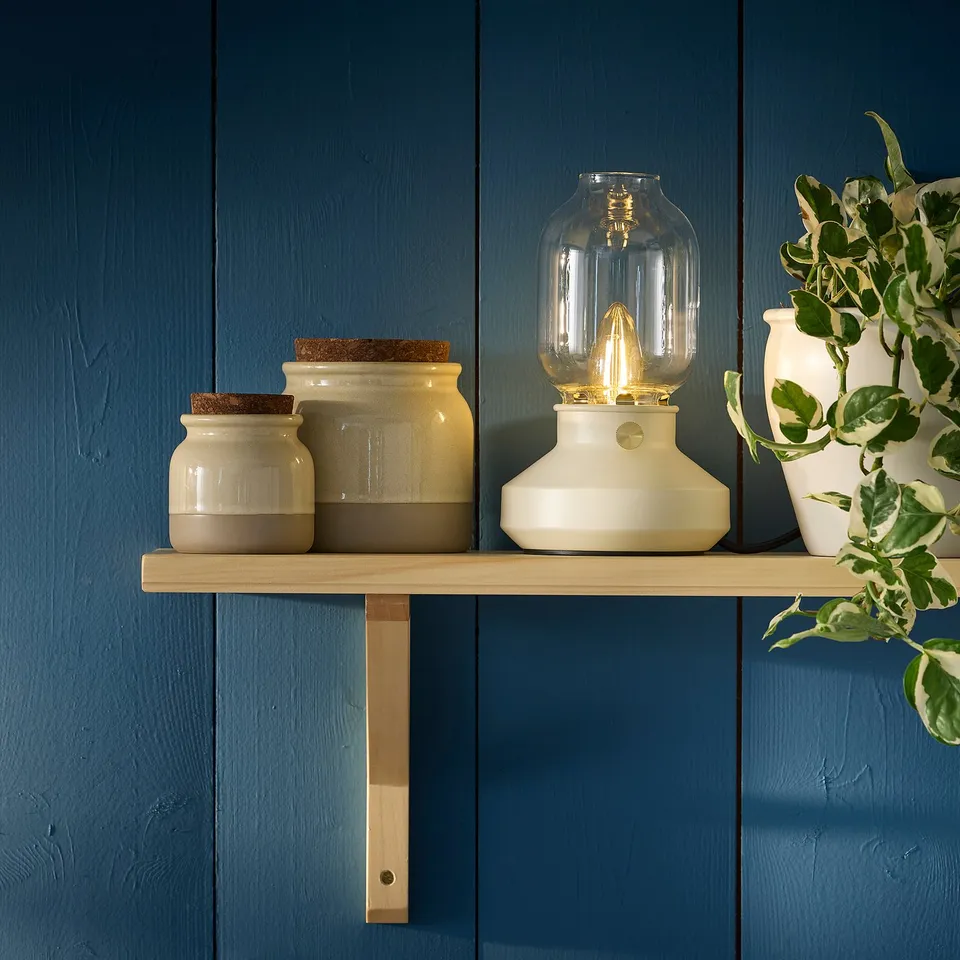 Small BRUGDHAJ jar with cork lid on shelf beside lamp.