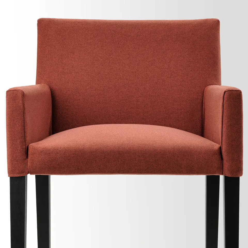Rust-red MÖRBYLÅNGA chair, padded seat, wide armrests, wooden legs. Modern dining comfort.