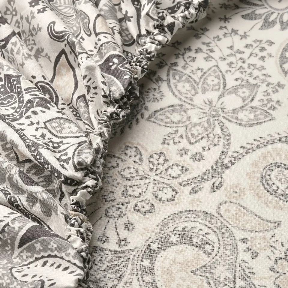 Paisley-patterned fitted sheet with ruffled edge, showcasing high-quality, soft fabric with intricate designs.