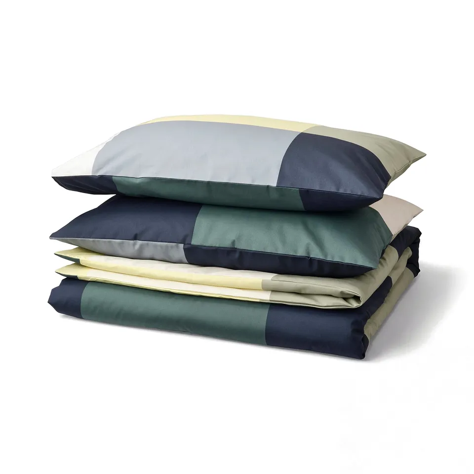 A stacked BRUNKRISSLA bedding set in green and blue chequered colour, featuring a cotton-viscose blend.
