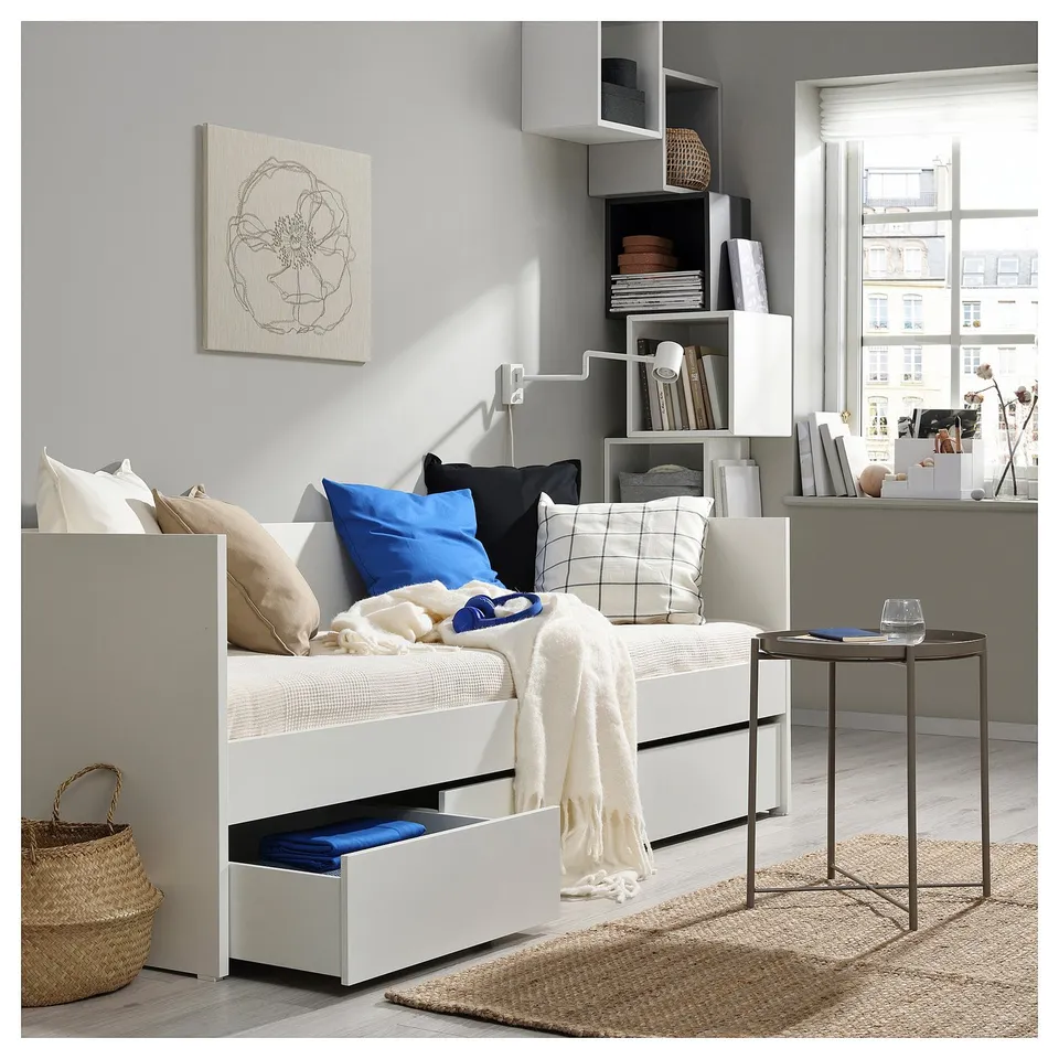 White VIHALS daybed in modern living space with storage, colourful pillows, cosy blanket.