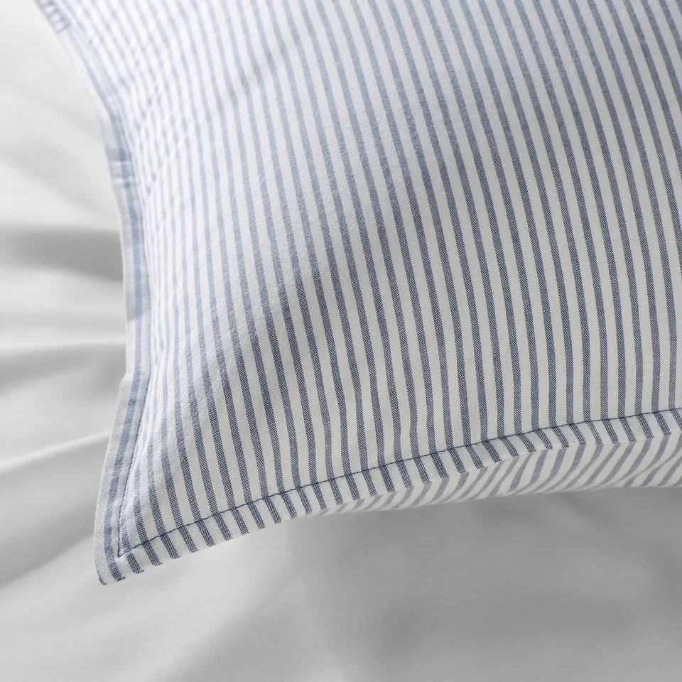 Close-up of striped blue-white pillowcase, showing quality stitching and fabric texture.