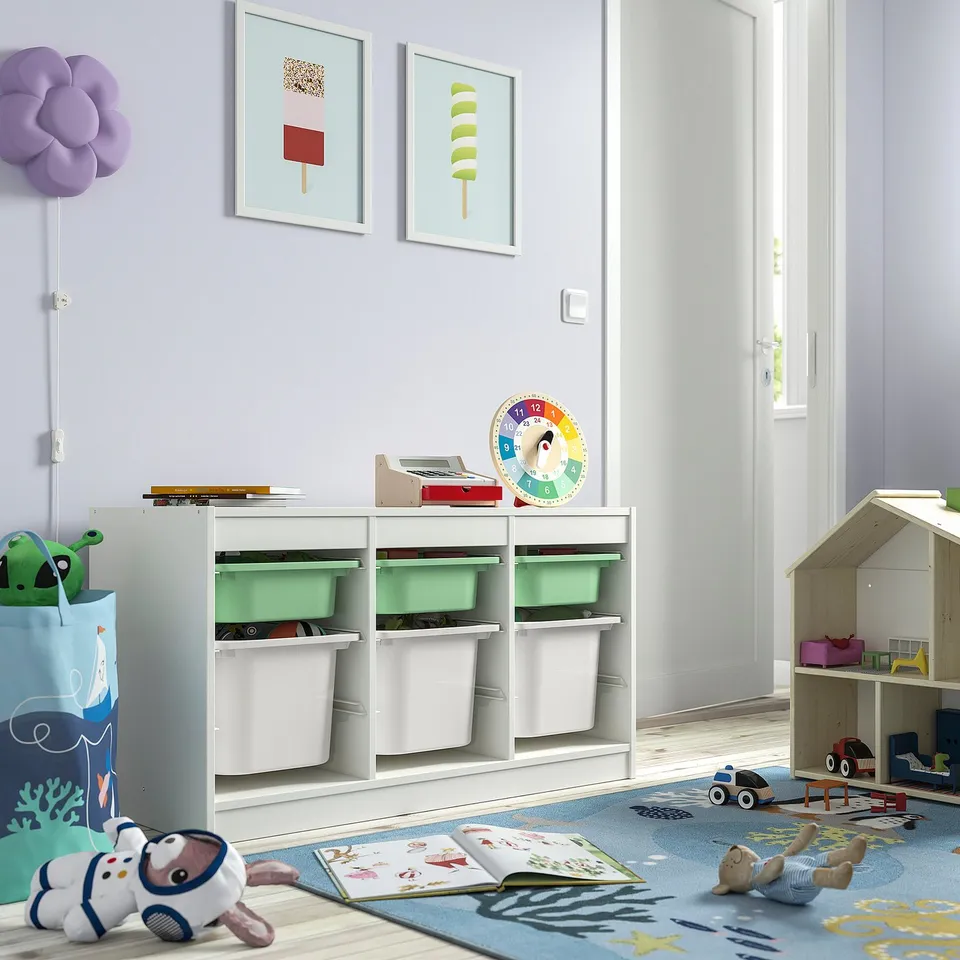 Childs playroom with TROFAST white storage units. Sized to fit neatly, holding colourful bins and toys. Bright, playful, and organised.