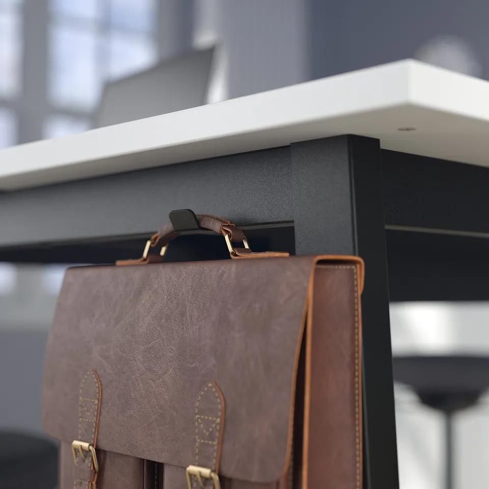 Brown leather bag hangs on black desk with shelf and hooks, showing storage and organisation.