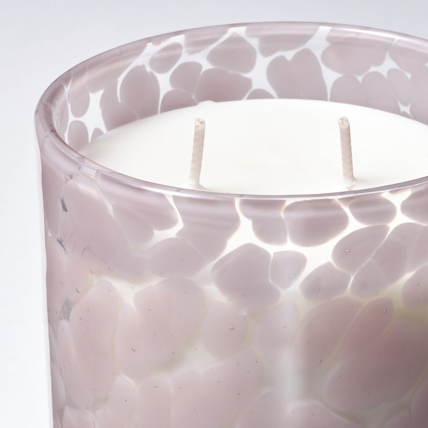 Elegant scented candle in textured glass with three wicks, exuding quality and luxury.