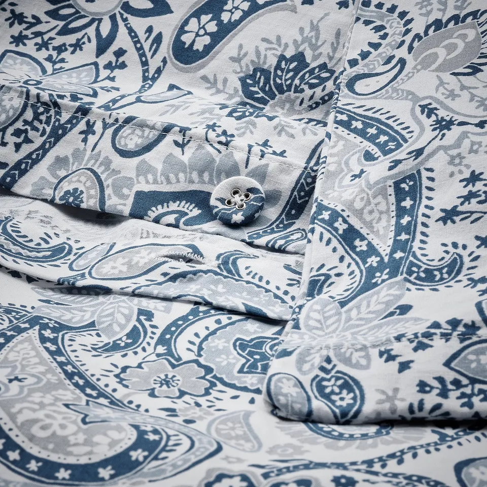 Paisley prints in blue and white decorate soft, breathable fabric with moisture-wicking and fine sheen qualities.