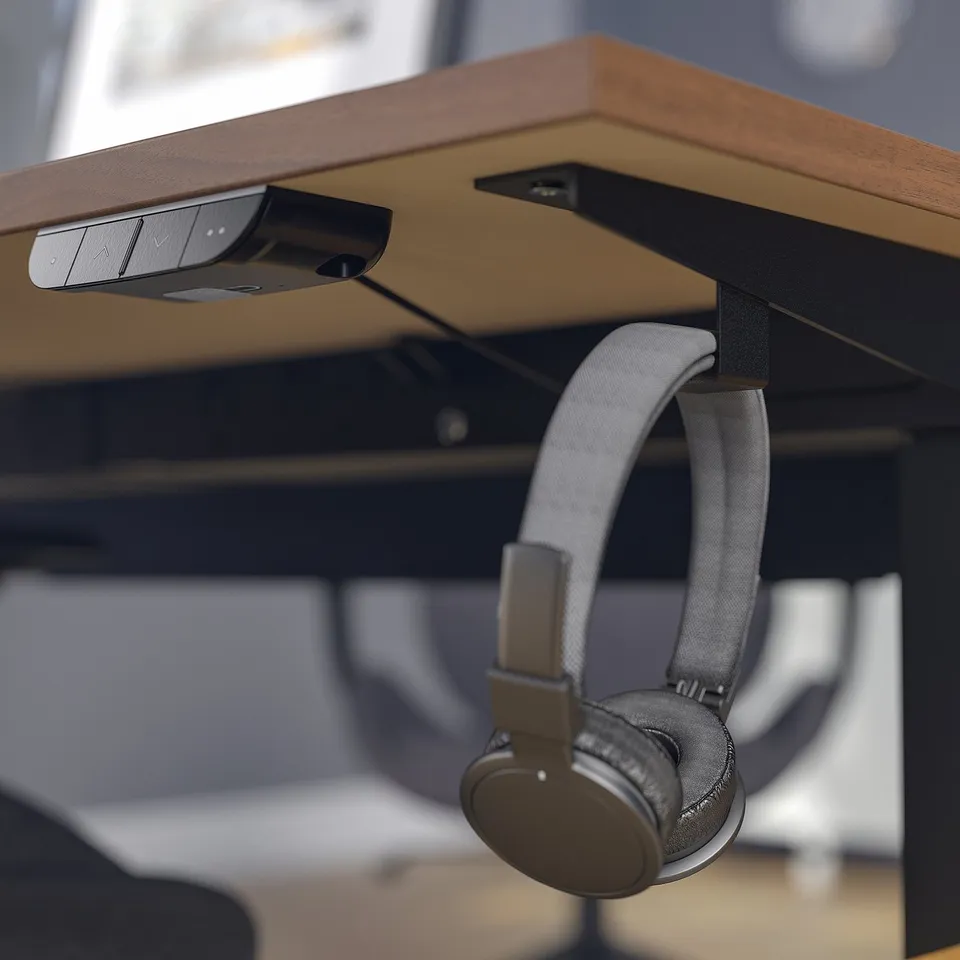 Under-desk headphone hook with cable management. Holds headphones and helps maintain a tidy workspace.