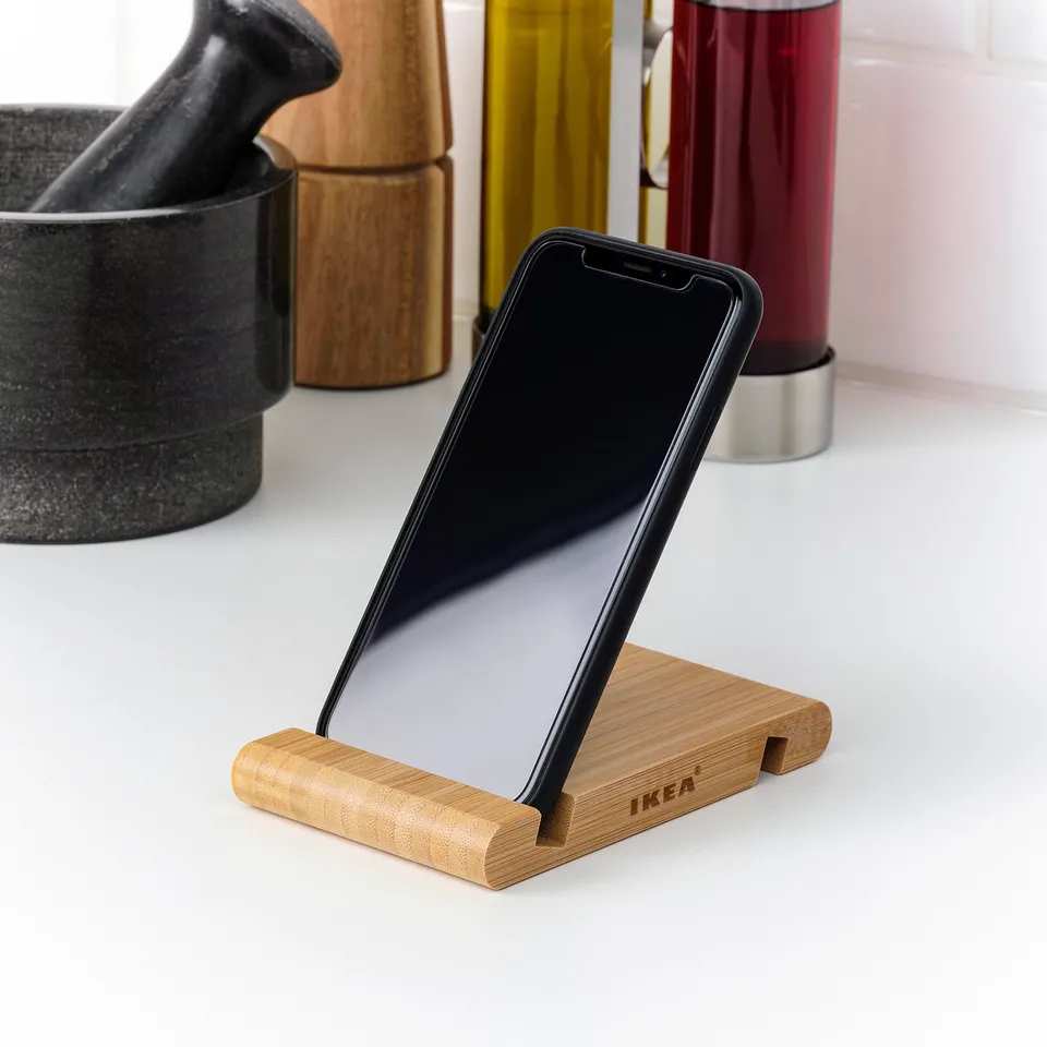 Bamboo mobile holder on counter, displaying a smartphone.
