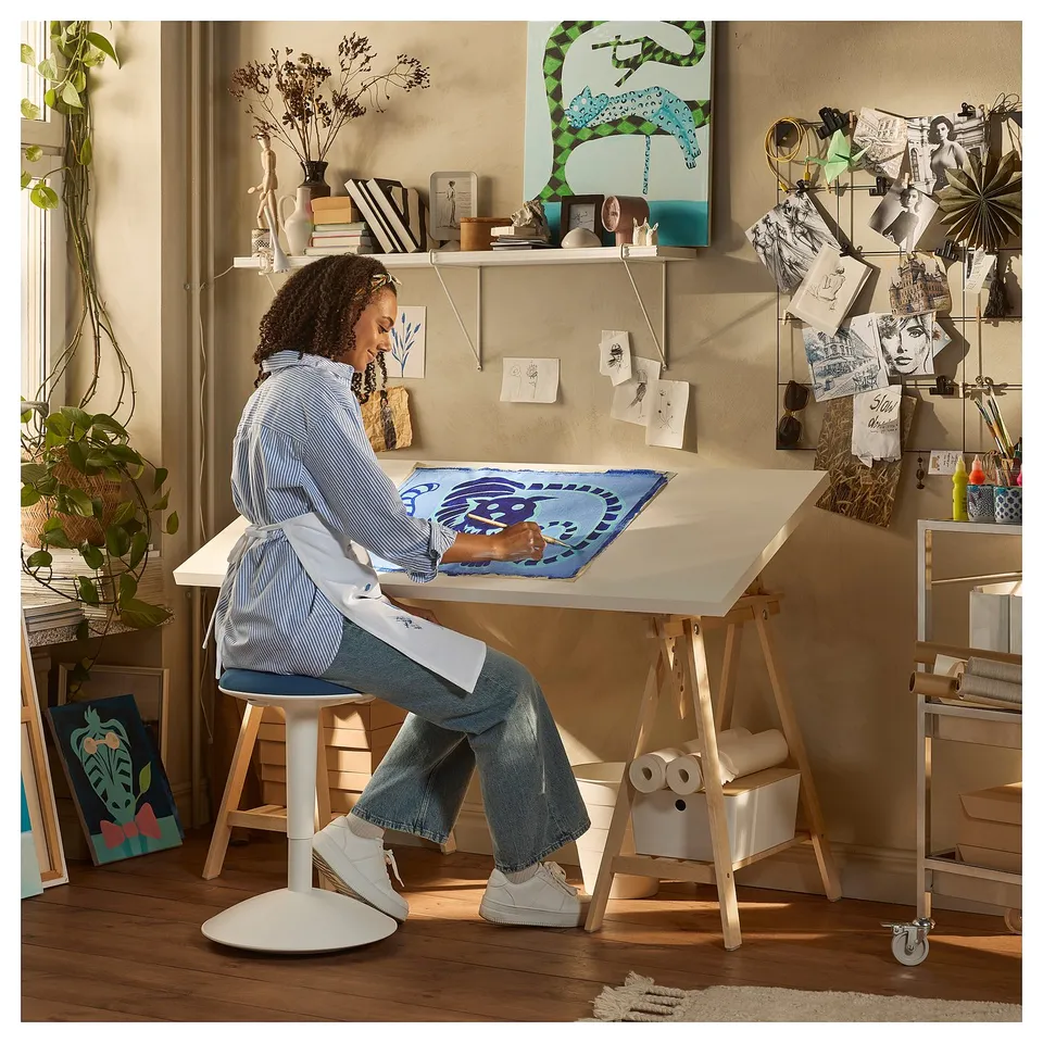 Person at LAGKAPTEN desk with blueprint.