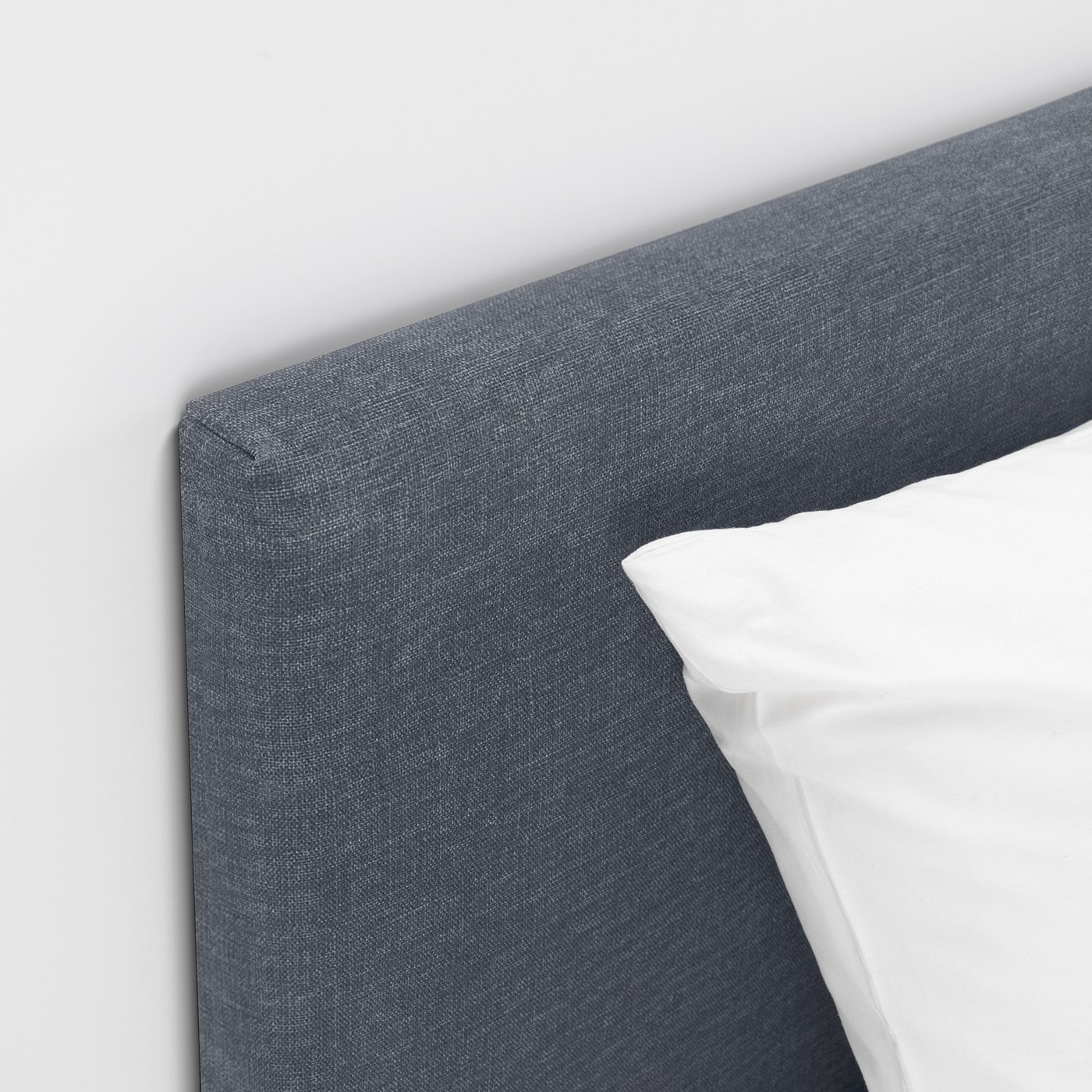 Grey fabric headboard of a modern, comfortable bed with clean lines and supportive design.