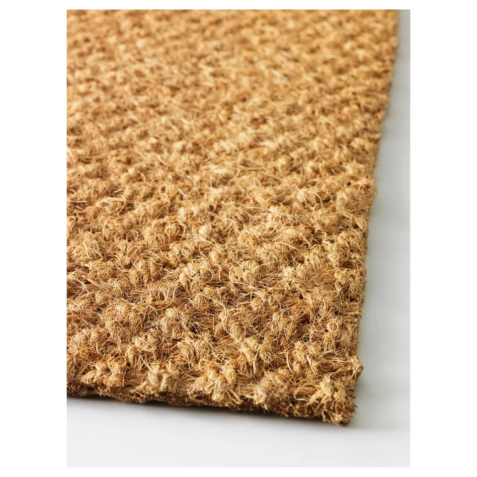 Close-up of a woven doormat, showcasing its natural coir texture and durable backing.