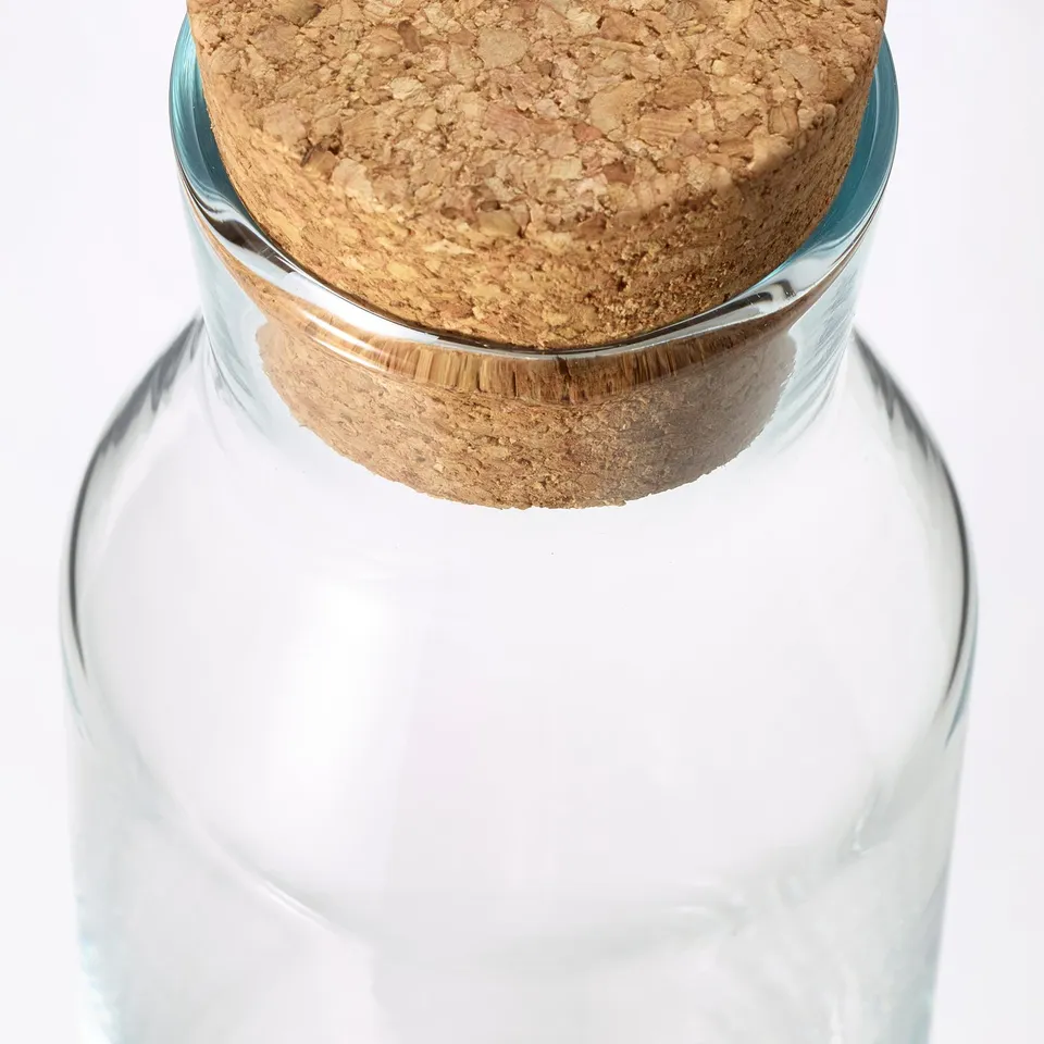 Clear glass carafe with cork stopper, durable and dishwasher-safe.