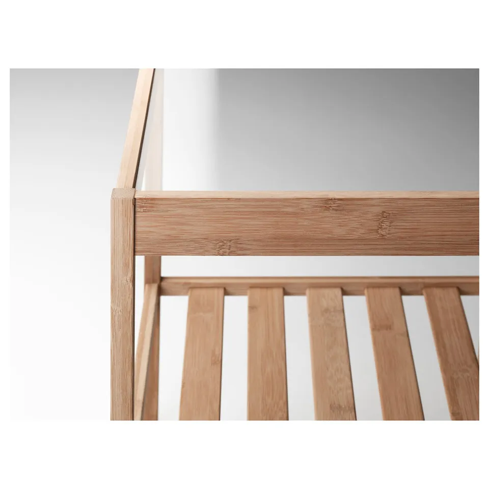 Close-up of sturdy bamboo table base with sleek glass top.