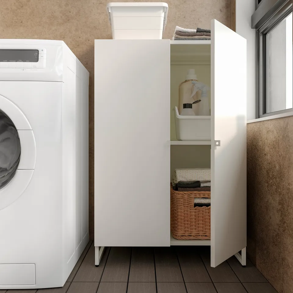Laundry room: white JOSTEIN cabinet with washing machine, shelves with basket, detergent, and clothes.