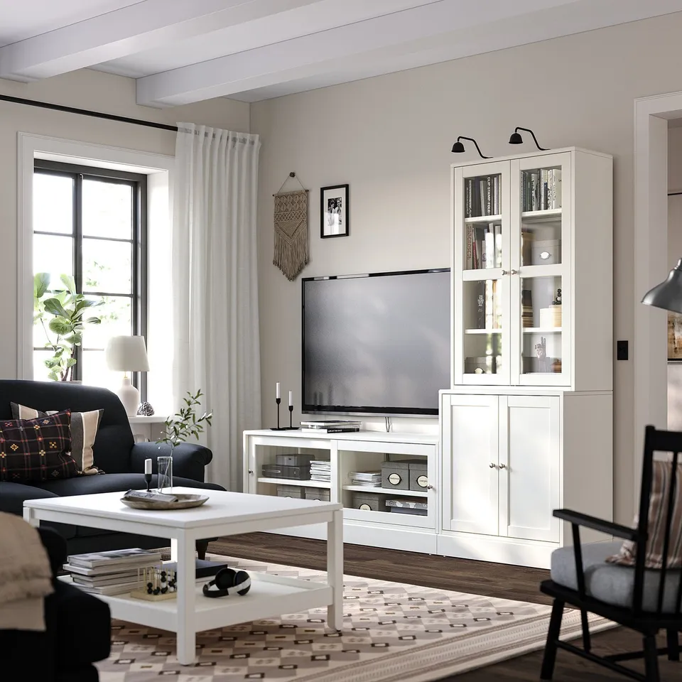 HAVSTA tv unit with books, black curtains, grey walls, dark couch, and rug.