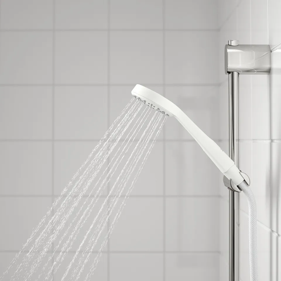 A white handshower spraying water, mounted on a metal arm, providing a full spray for a relaxing shower.