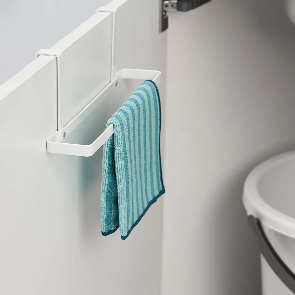 White over-door towel rack with blue striped towel hanging, saving kitchen space.