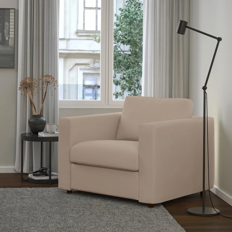 Modern living room: beige VIMLE armchair, black floor lamp, side table with vase.