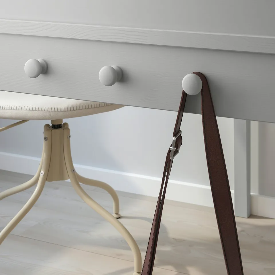 Desk with drawer and side knobs for hanging items; part of SMYGA series.